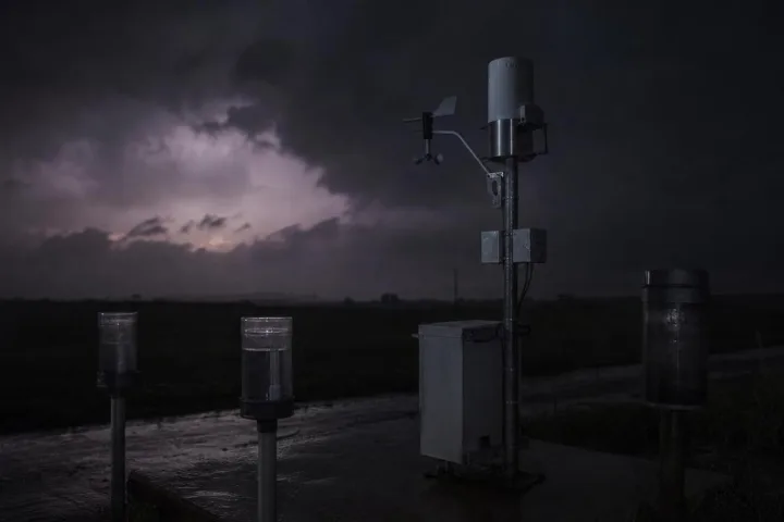 Una stazione meteo isolata sotto nuvole nere, lontana dalle strade illuminate
