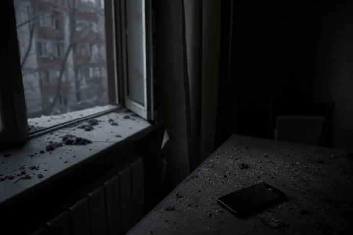Telefono spento su un tavolo mentre la cenere si posa alla finestra