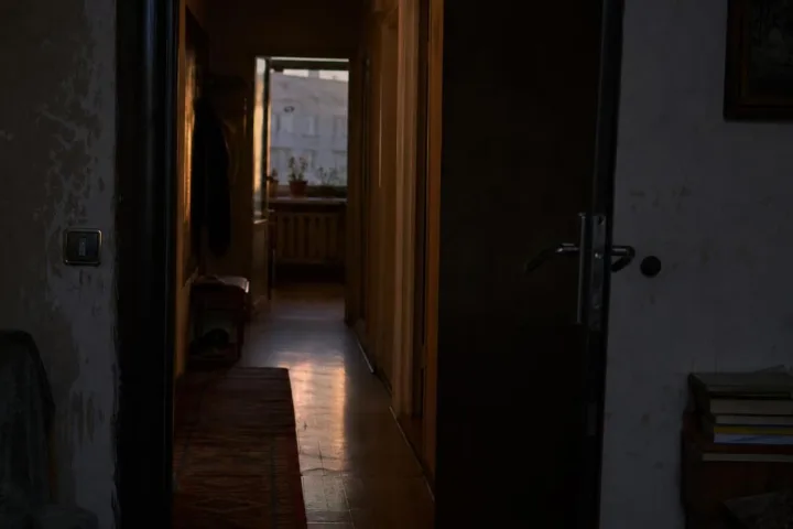 Il corridoio buio del condominio visto da una porta socchiusa