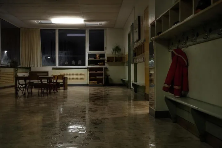 Corridoio di scuola materna notturna con cappotto rosso e impronte sul pavimento